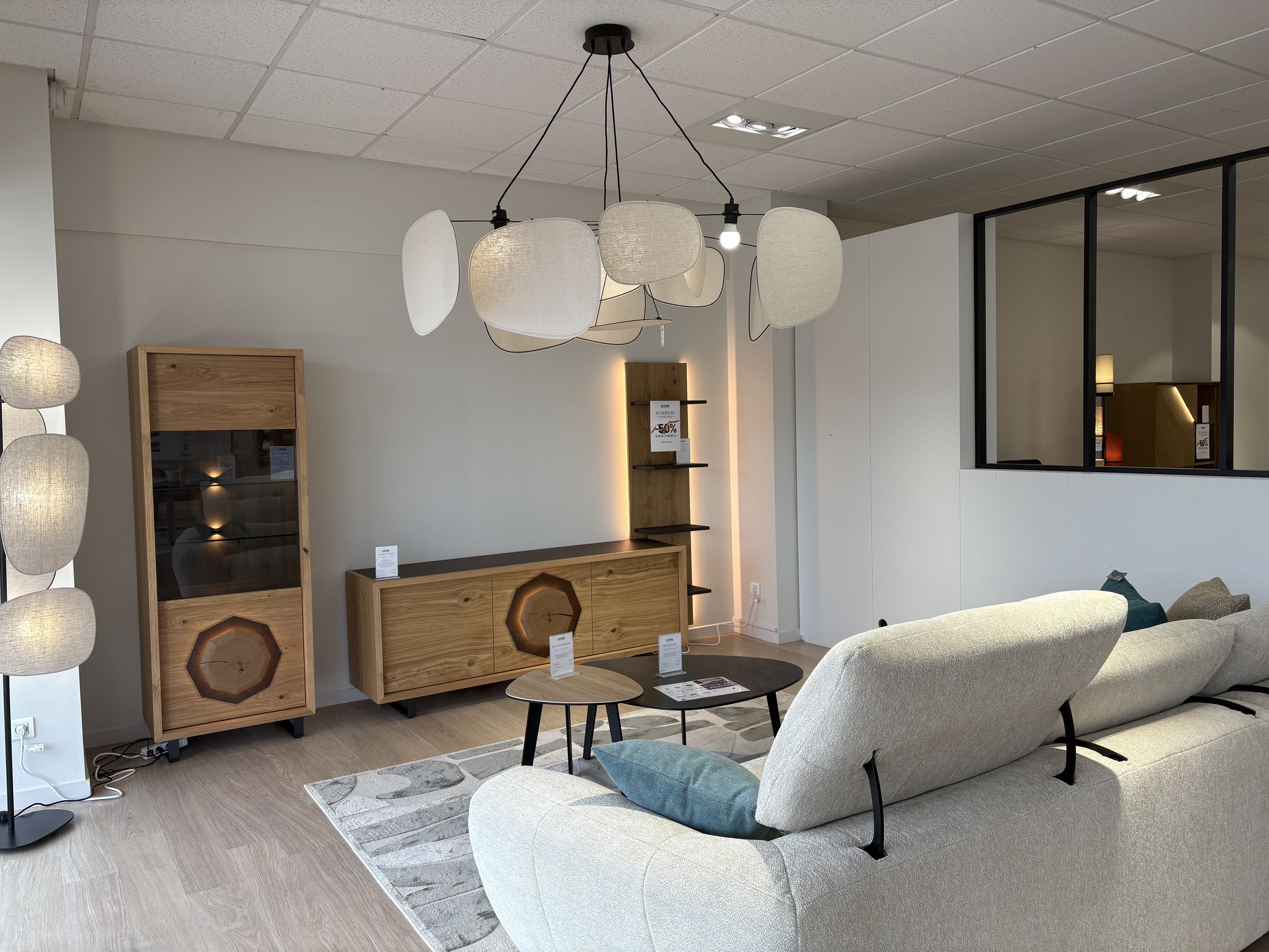 Salon lumineux avec canapé en tissu écru, buffet en chêne et suspension en lin